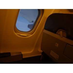 Interior of Dimly Lit Airplane with View of Sky Out of Open Window 